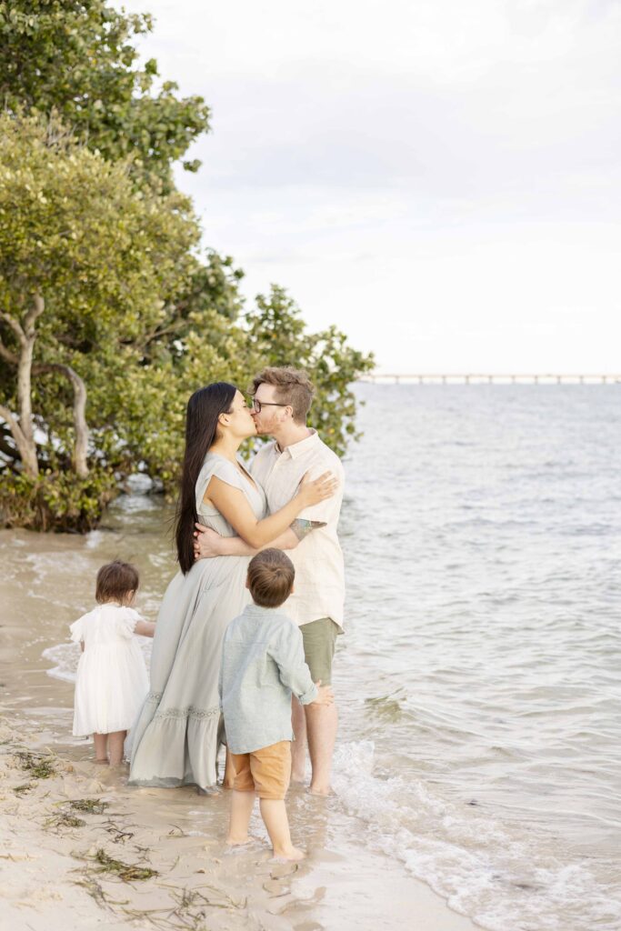 Brisbane Family Portraits | A little boy watches his parents share a kiss, while the little girl stands by their side | Sharon Joseph Photography