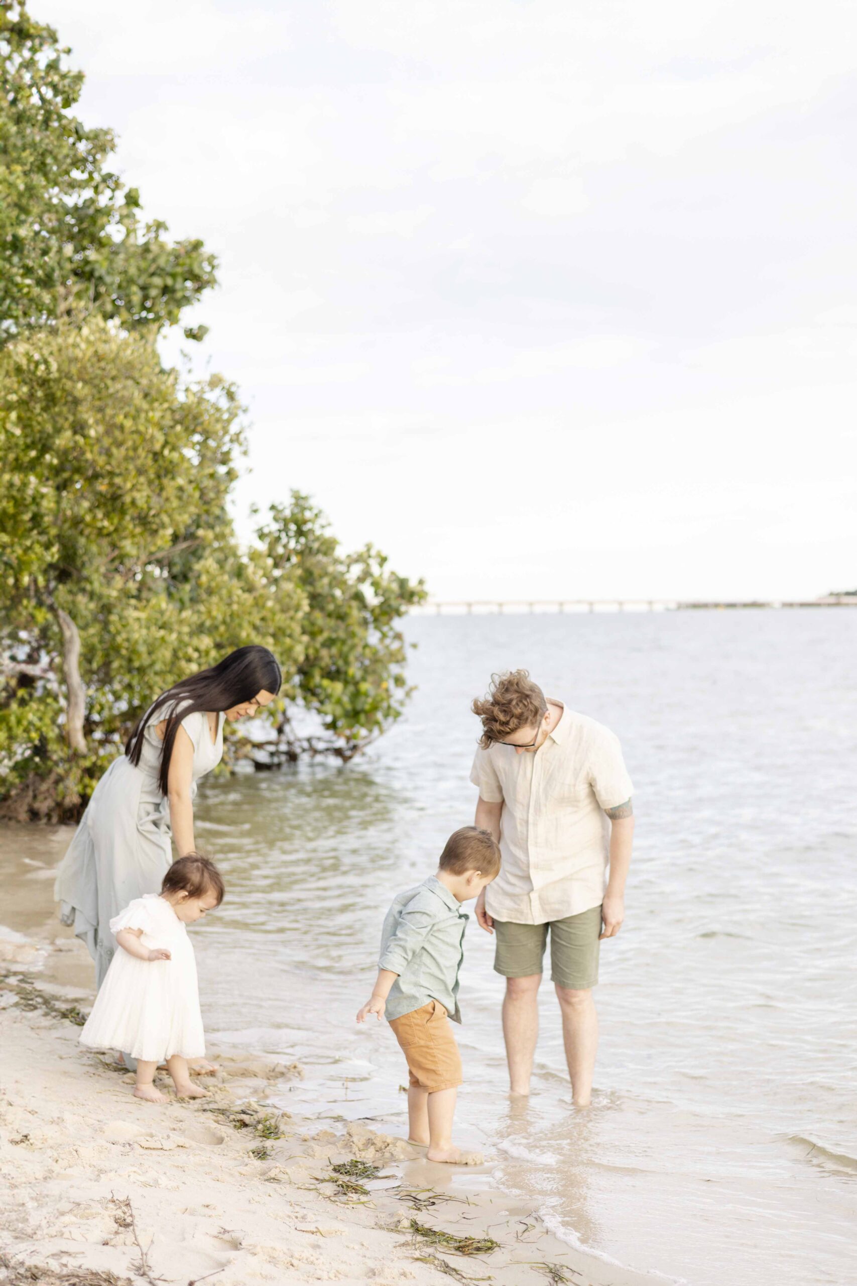 Brisbane beach family photos. Family of four playing at the water's edge. Sharon Joseph Photography, North Brisbane Family Photographer