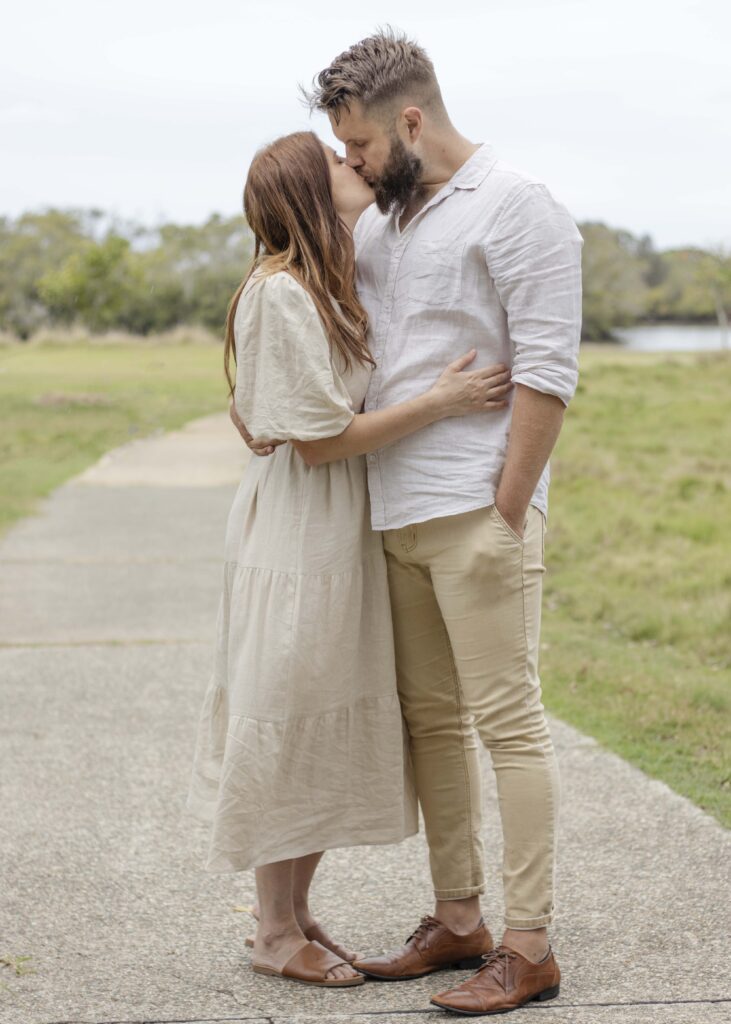 Two young parents sharing a kiss. 