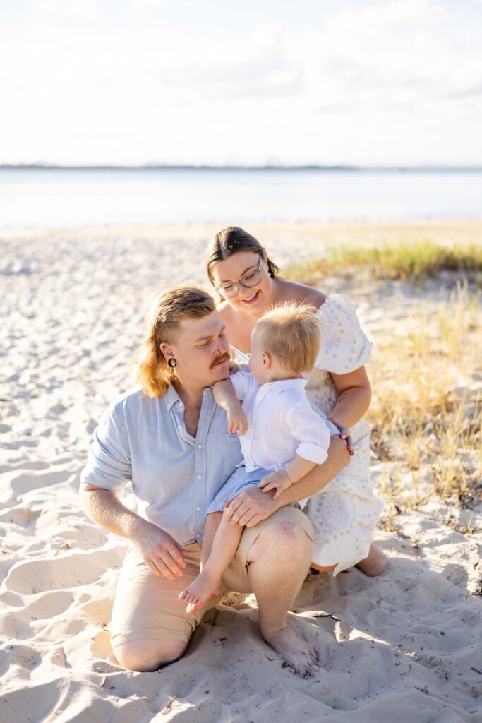 Family photo at Brisbane beach with mum, dad and toddler.