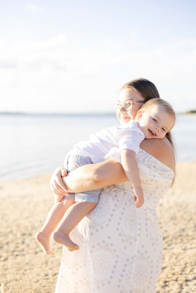 A smiley toddler carried by his pregnant mum. Brisbane family photography.