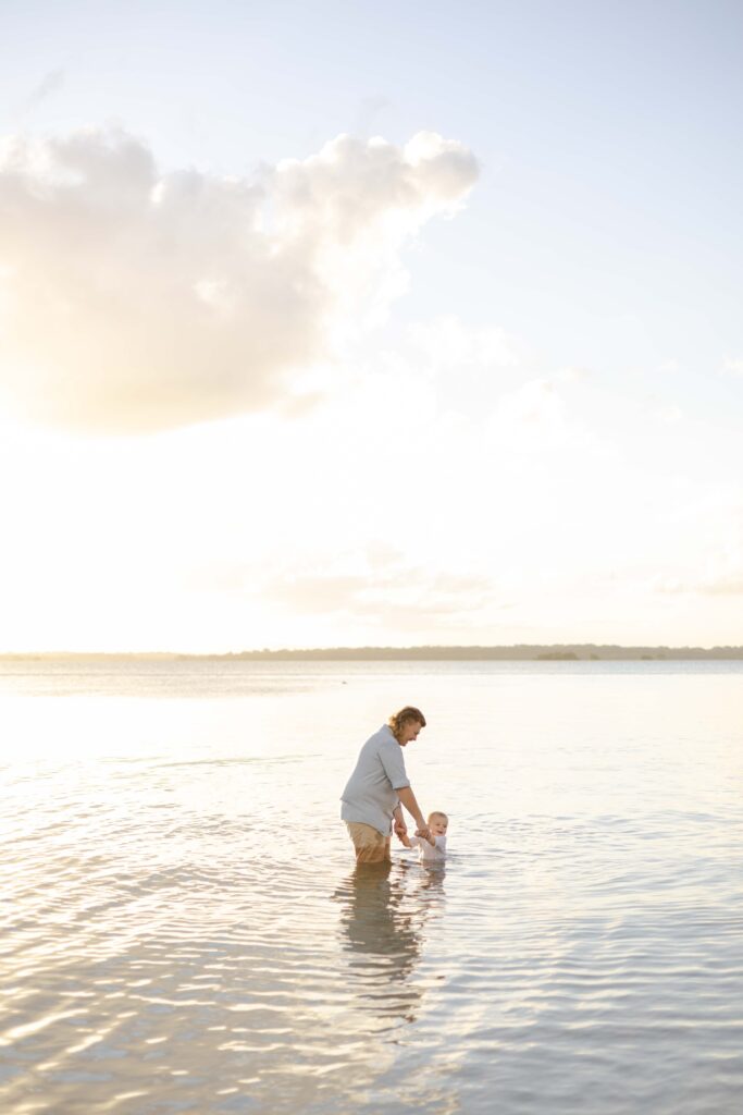 Dad and son playing in the sea. Brisbane family photography.