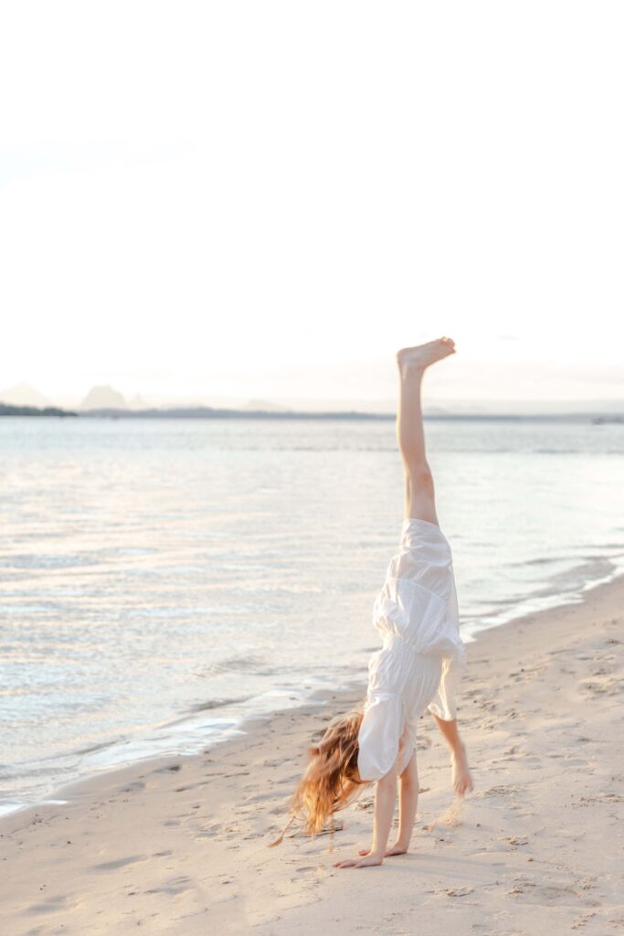 Girl doing a cartwheel on Bribie Island. 