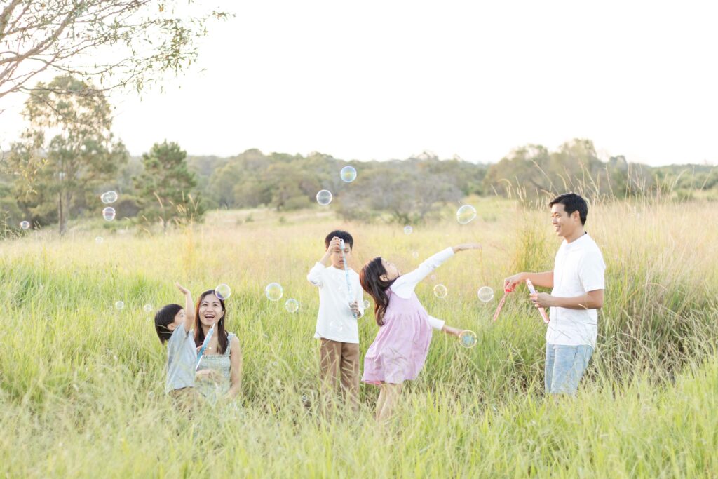 family enjoying blowing and popping bubbles