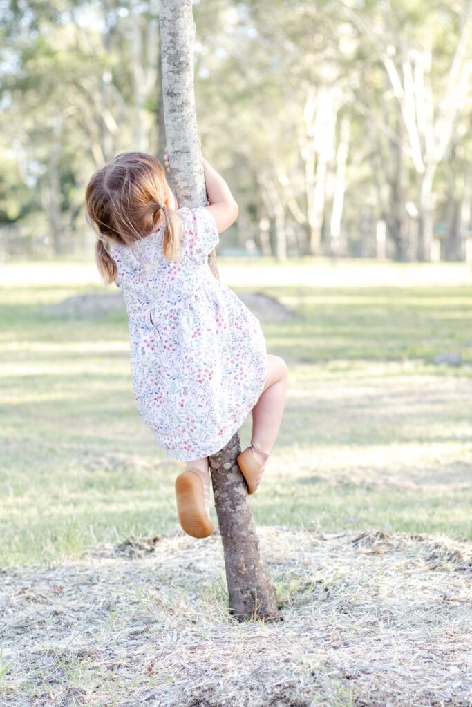 Little girl climbing a tree