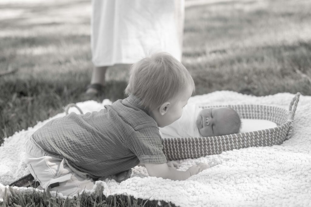 Big brother admiring newborn baby brother. Taken during outdoor morning photoshoot in Brisbane