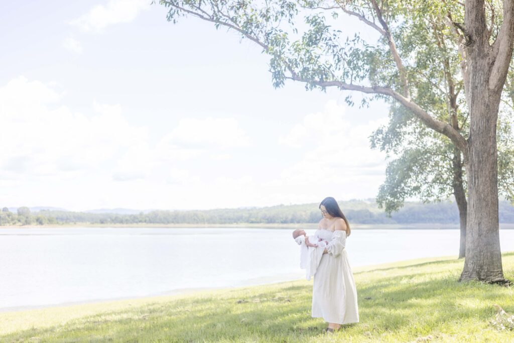 Beautiful photo of mum holding her newborn, taken during outdoor morning photoshoot in Brisbane