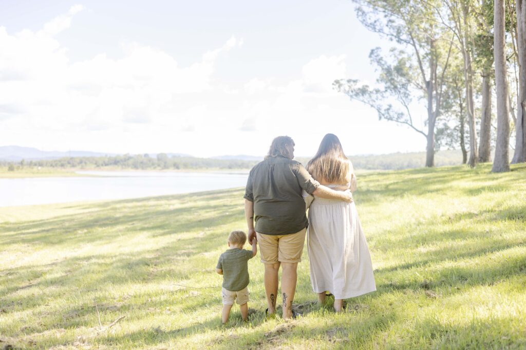 photo of family walking by a lake, taken from the back.