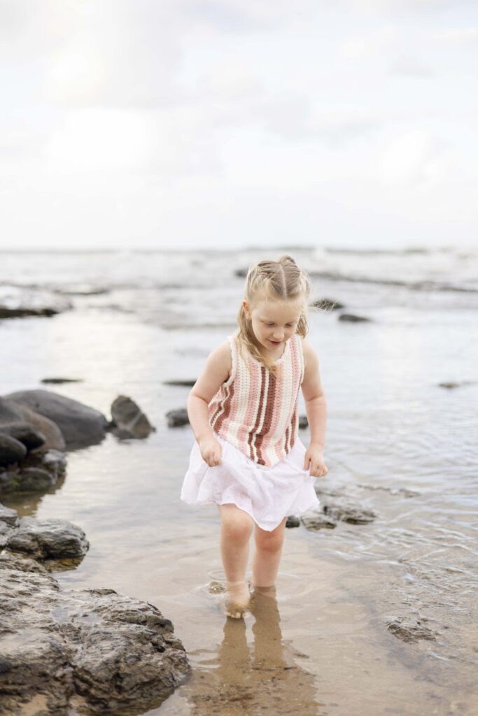 A little girl exploring the rock pools at Point Cartwright
