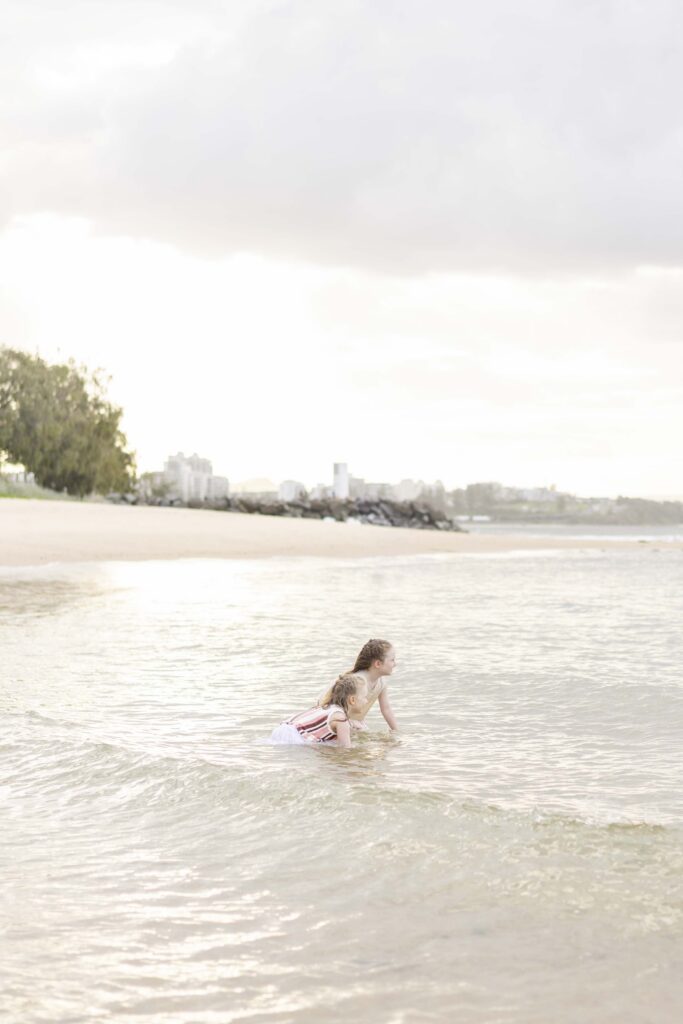 Two little kids swimming  at Point Cartwright Beach