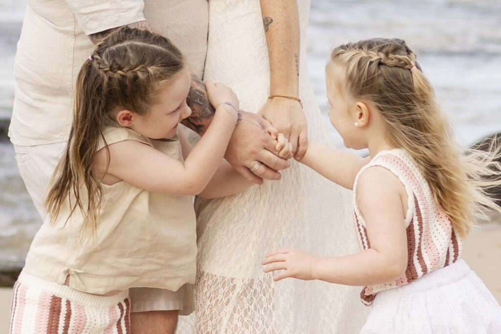 Cute family holding hands at their family photoshoot at Point Cartwright on Sunshine Coast