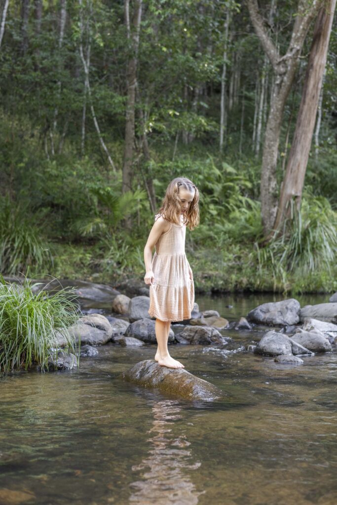 Little girl standing on a rock near a creek in Samford