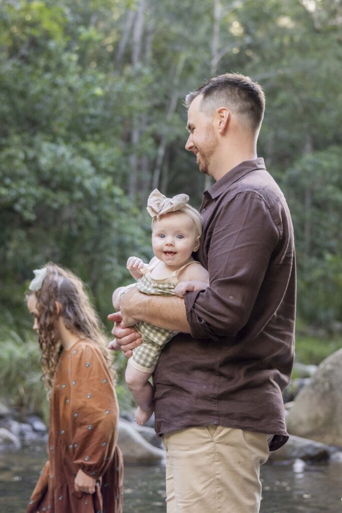 Baby with big, gunny smile while her dad is holding her