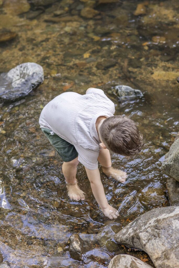 Best creeks in Brisbane. Boy picking up rocks from creek with clear water