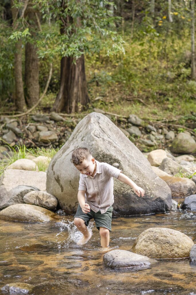 Little boy happily splashing on this family-friendly shallow creek near Brisbane