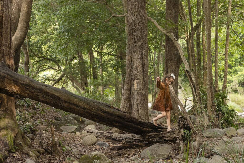 Little girl walking on a fallen tree trunk, near Cedar Creek