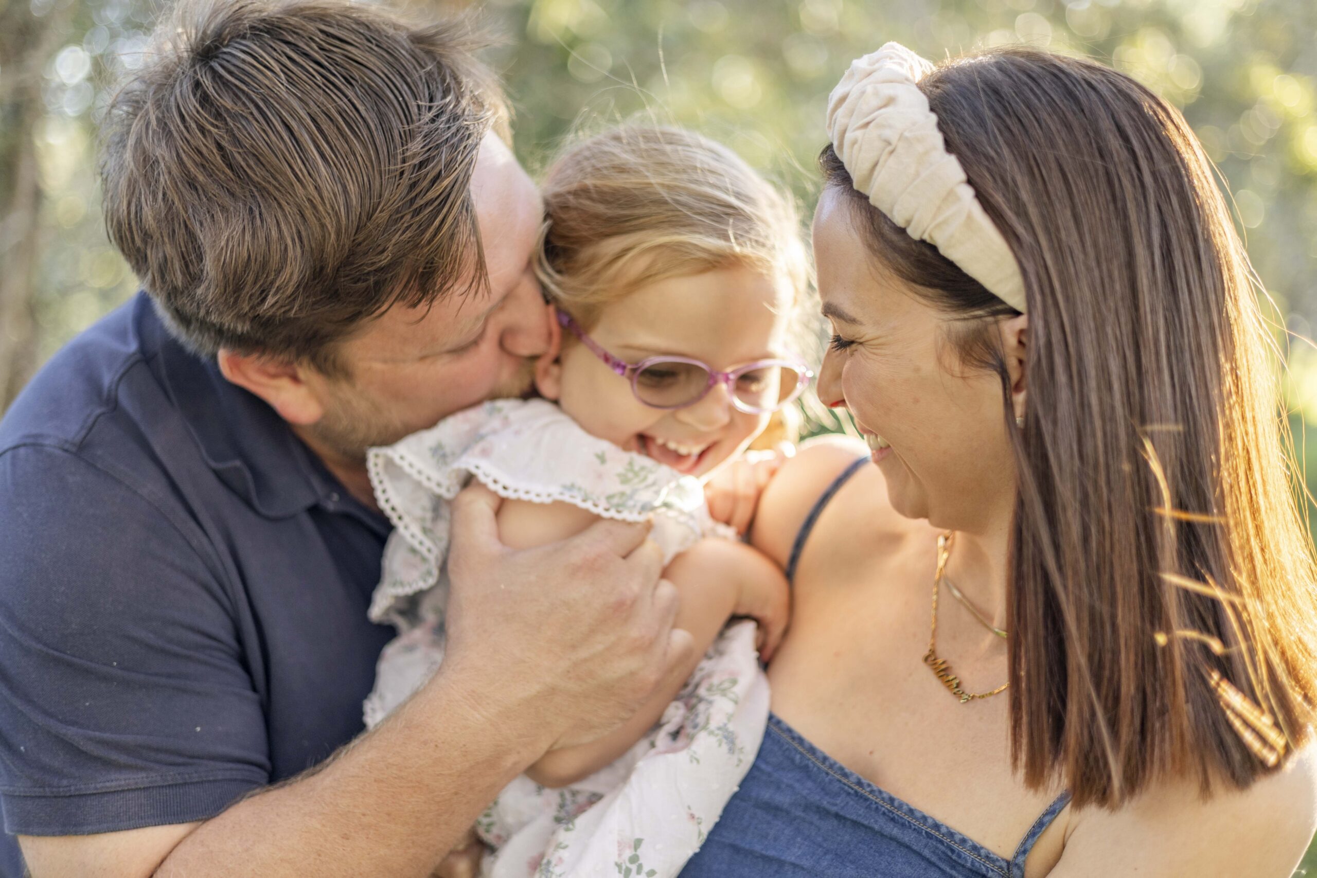 Parents smiling at happy toddler during their relaxed family photography session in Brisbane