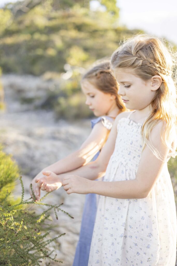 Sisters exploring plants on their bushwalk during a Brisbane family photoshoot