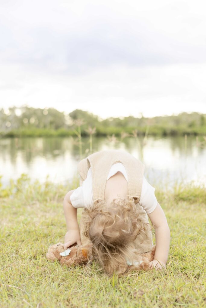 Toddler trying to do a headroll during a fun family photography session in North Brisbane
