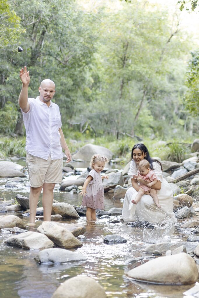 Young family throwing rocks in Cedar Creek at their family photography session in Brisbane