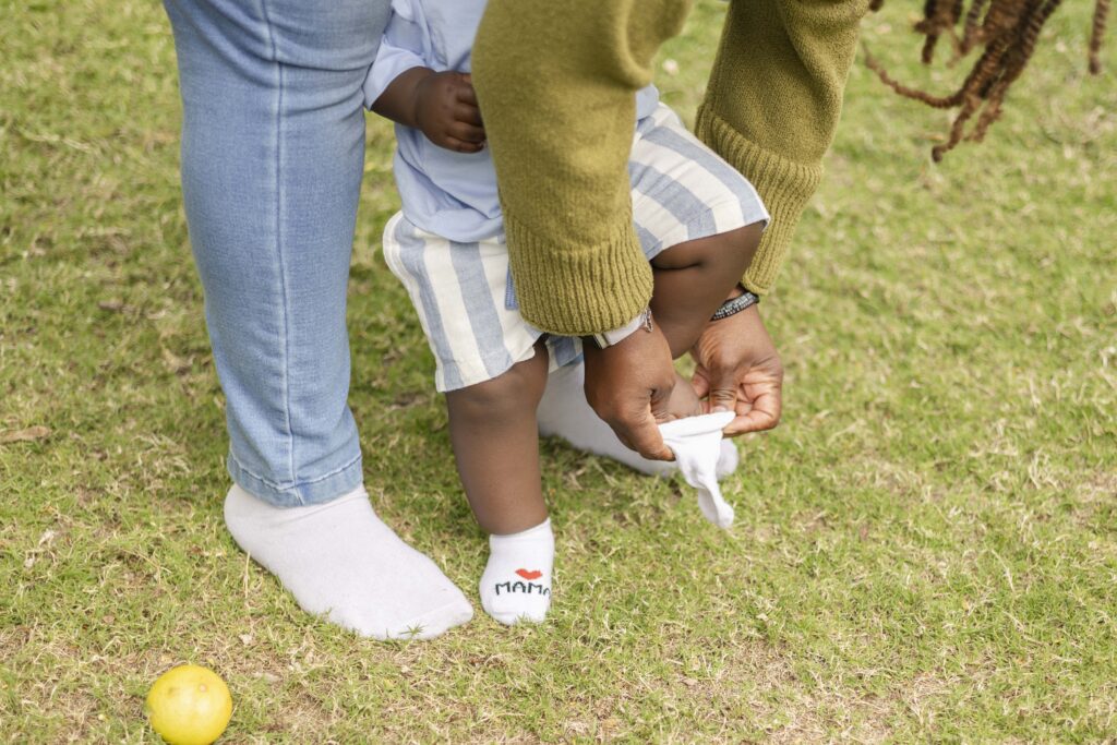 Mum putting sock on baby during a candid shot at a family photography session in North Brisbane